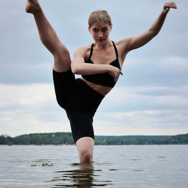 Man focused on a complex physical pose, illustrating body control and stability.