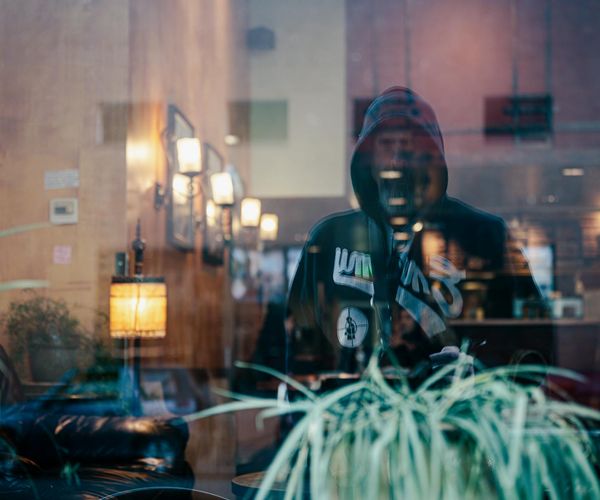 Silhouette of a person standing on a hill looking at a city, symbolizing daily life.